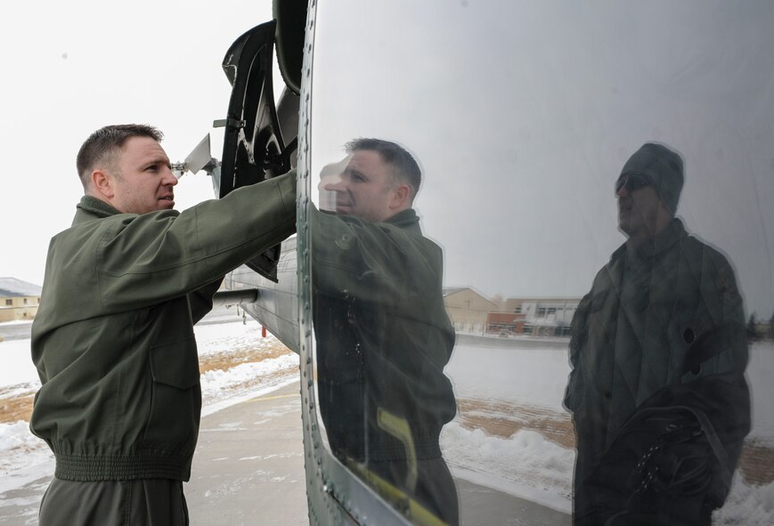 Master Sgt. Jordan Bunting (left), and Tech. Sgt. Scott Grubaugh (right), 54th Helicopter Squadron special mission aviators, check the engine compartment of a UH-1N helicopter on Minot Air Force Base, N.D., Jan. 21, 2014. Pre-flight checks are conducted before every mission to ensure the aircraft is in the proper condition for flight. (U.S. Air Force photo/Senior Airman Stephanie Morris)
