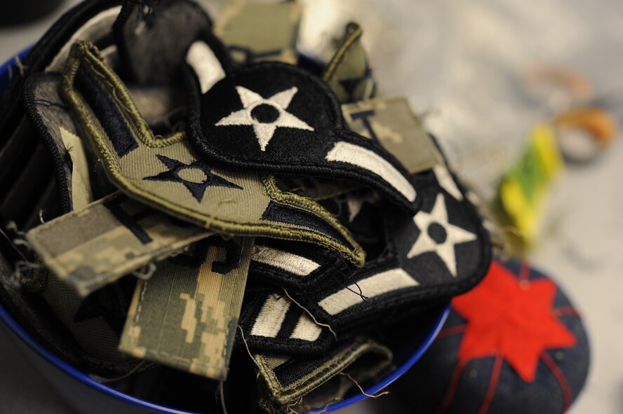 Rank insignia and name tapes fill a bowl at the clothing alterations shop on Minot Air Force Base, N.D., Jan. 21, 2015. Fabric name tapes, Air Force tapes, occupational badges and metal and plastic name tapes are available for purchase at the clothing sales shop next door to alterations at military clothing sales. (U.S. Air Force photo/Senior Airman Stephanie Morris)