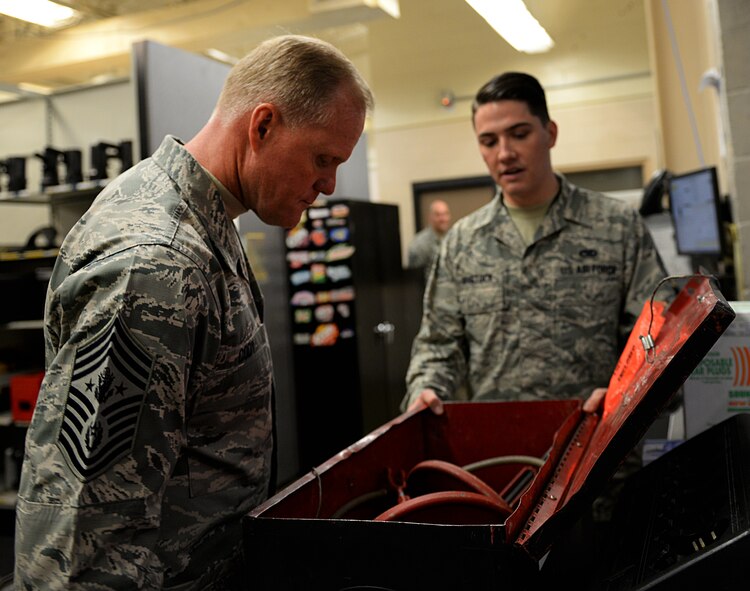 Senior Airman Matthew Binstock, 2nd Maintenance Squadron phase inspection journeyman, speaks to Chief Master Sgt. of the Air Force James Cody about the functions of a flap swing on Barksdale Air Force Base, La., Jan. 23, 2015. Maintenance Airmen use flap swings to install and remove B-52H Stratofortress aircraft wing flaps. (U.S. Air Force photo/Airman 1st Class Curt Beach)