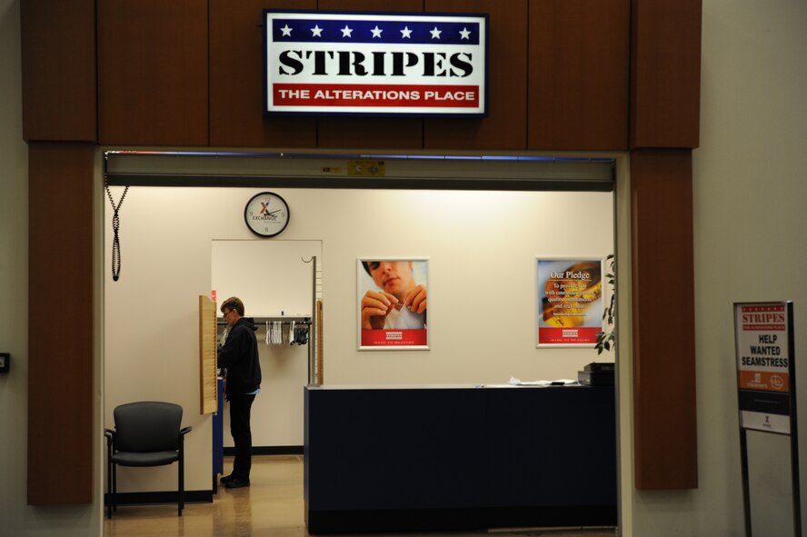 Michelle Offman, alterations shop concessionaire, removes rank insignia and name tapes from uniforms at the clothing alterations shop on Minot Air Force Base, N.D., Jan. 21, 2015. In addition to making alterations to military uniforms, the shop also alters civilian attire such as dress slacks and formal jackets. (U.S. Air Force photo/Senior Airman Stephanie Morris)
