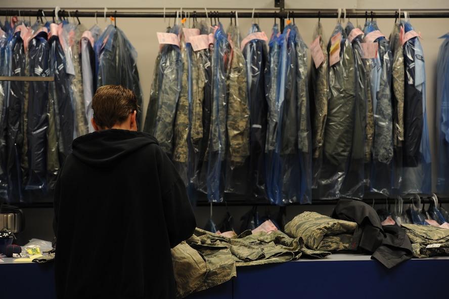 Michelle Offman, alterations shop concessionaire, removes rank insignia and name tapes from uniforms at the clothing alterations shop on Minot Air Force Base, N.D., Jan. 21, 2015. In addition to making alterations to military uniforms, the shop also alters civilian attire such as dress slacks and formal jackets. (U.S. Air Force photo/Senior Airman Stephanie Morris)