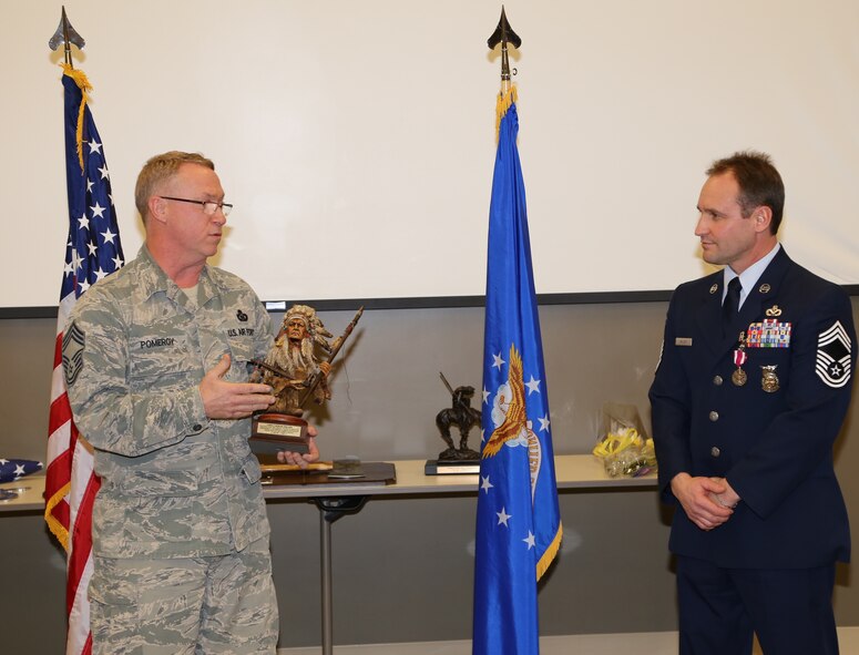 Chief Master Sgt. Kevin Pomeroy from the 932nd Operations Group tells a story of praise to retiring Chief Master Sgt. Roger Miller who was later surrounded by the 932nd firefighters during a final farewell following his retirement ceremony on January 10 at the 932nd Airlift Wing. (U.S. Air Force photo/Maj. Stan Paregien)