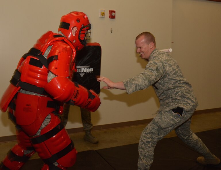 This practice might hurt in the morning!  Col. Karl Goerke, 932nd Airlift Wing commander, pushes back with a combative-style technique used during law-enforcement training at Scott Air Force Base. The Red Man suit, pictured, is the newest addition to tactical training equipment used by the 932nd Security Forces Squadron. (U.S. Air Force photo/Tech. Sgt. Christopher Parr)