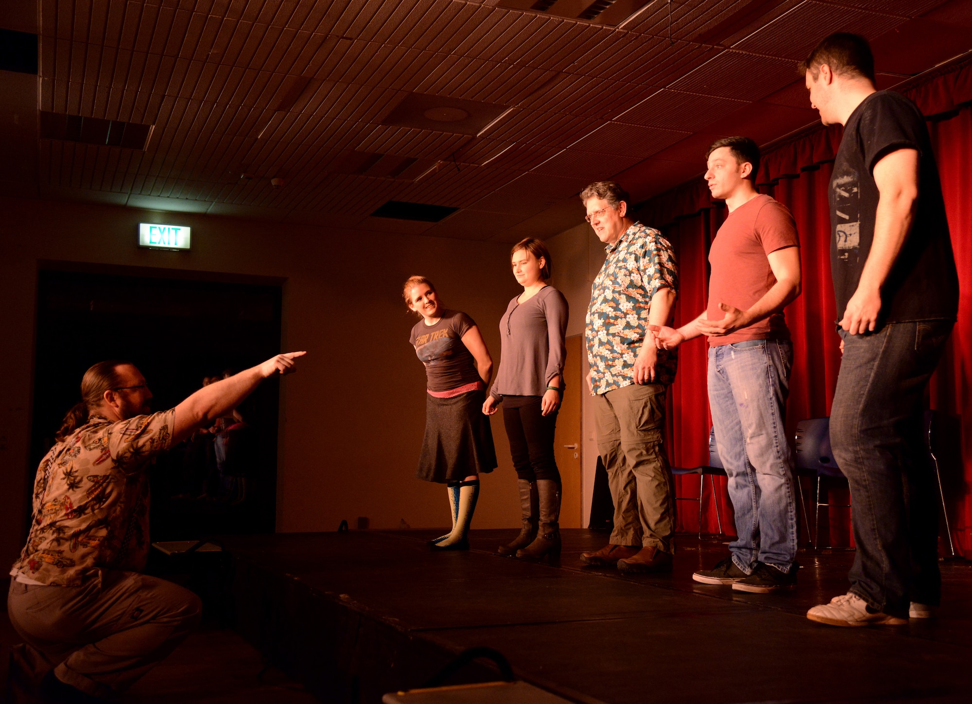 Edison Ruland, 86th Force Support Squadron recreation specialist, directs members of Strike Force Comedy during “New Year Nuttiness” at Ramstein Air Base, Germany, Jan. 24, 2015. Strike Force Comedy is an improv club comprised of members of the Kaiserslautern Military Community. (U.S. Air Force photo/Senior Airman Timothy Moore)