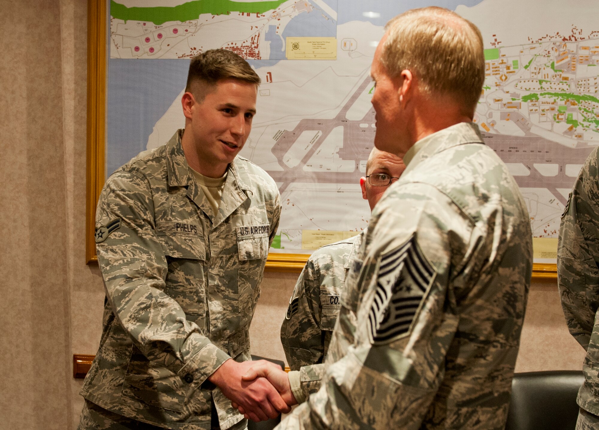 Chief Master Sgt. of the Air Force James A. Cody presents a coin to Airman 1st Class Justin Phelps, Armed Forces Network, Lajes Field, Azores, Portugal, on January 26, 2015. Cody is currently on a tour of bases within the United States Air Forces in Europe command to express his gratitude to Airmen, listen to their concerns and answer their questions. (U.S. Air Force photo/Staff Sgt. Zachary Wolf/Released)