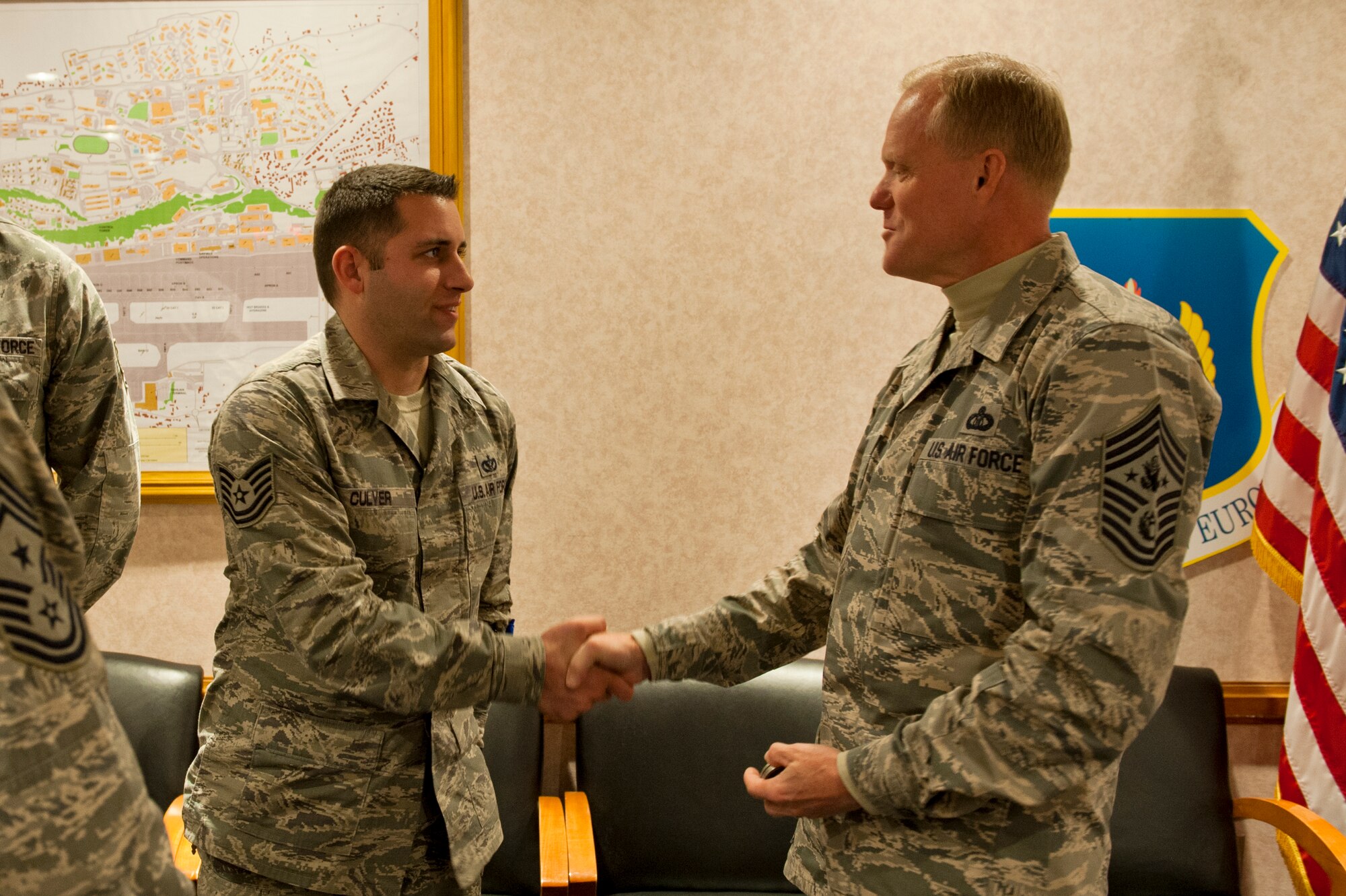 Chief Master Sgt. of the Air Force James A. Cody presents a coin to Technical Sgt. Adam Culver, 65th Civil Engineering Squadron, Lajes Field, Azores, Portugal, on January 26, 2015. Cody is currently on a tour of bases within the United States Air Forces in Europe command to express his gratitude to Airmen, listen to their concerns and answer their questions. (U.S. Air Force photo/Staff Sgt. Zachary Wolf/Released)