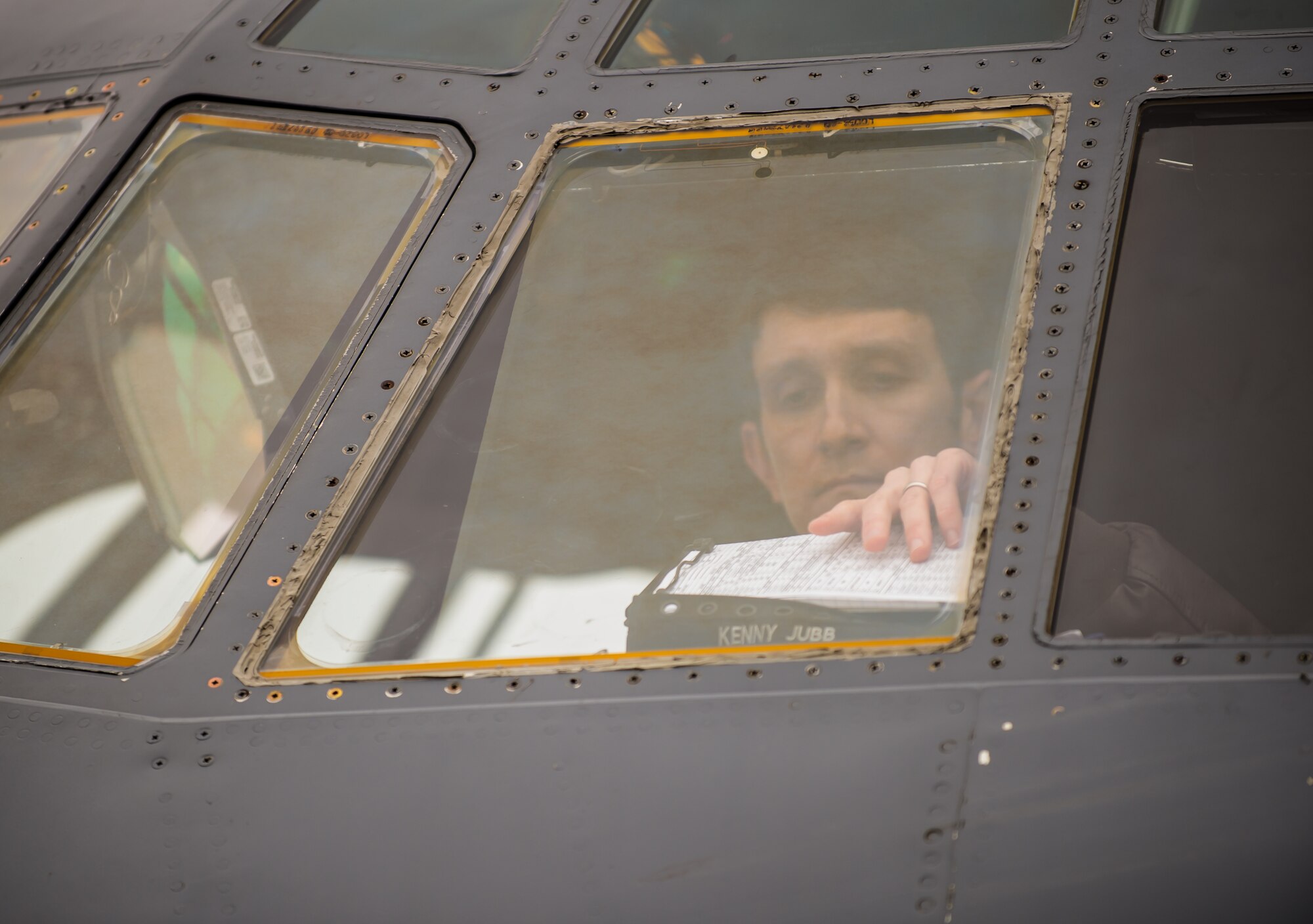 Capt. Kenneth Jubb, 37th Airlift Squadron pilot, reaches for his clipboard to review flight plans during a training mission in a C-130J Super Hercules Jan. 22, 2015, at Ramstein Air Base, Germany. The intent of the mission was to train Jubb and the co-pilot in flying at 7,000 feet as well as performing a simulated cargo drop to maintain proficiency. (U.S. Air Force photo/Senior Airman Jonathan Stefanko)