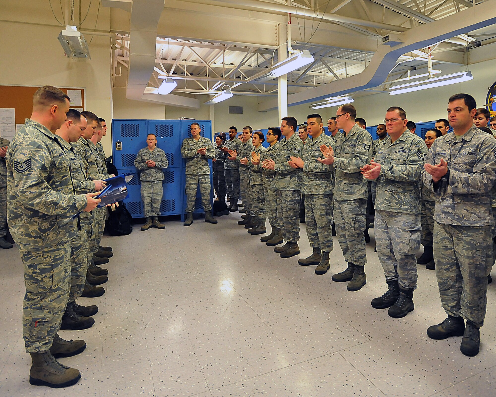 Members from the 92nd Aircraft Maintenance Squadron applaud five Airmen from their squadron who received Navy and Marine Corps Achievement Medals Jan. 23, 2015, at Fairchild Air Force Base, Wash.  The members are all propulsions systems technicians and assisted the U.S. Navy with engine issues while they were here for an exercise. This team completed maintenance that usually takes 24 to 36 hours in a 12-hour shift. (U.S. Air Force photo/Staff Sgt. Veronica Montes)