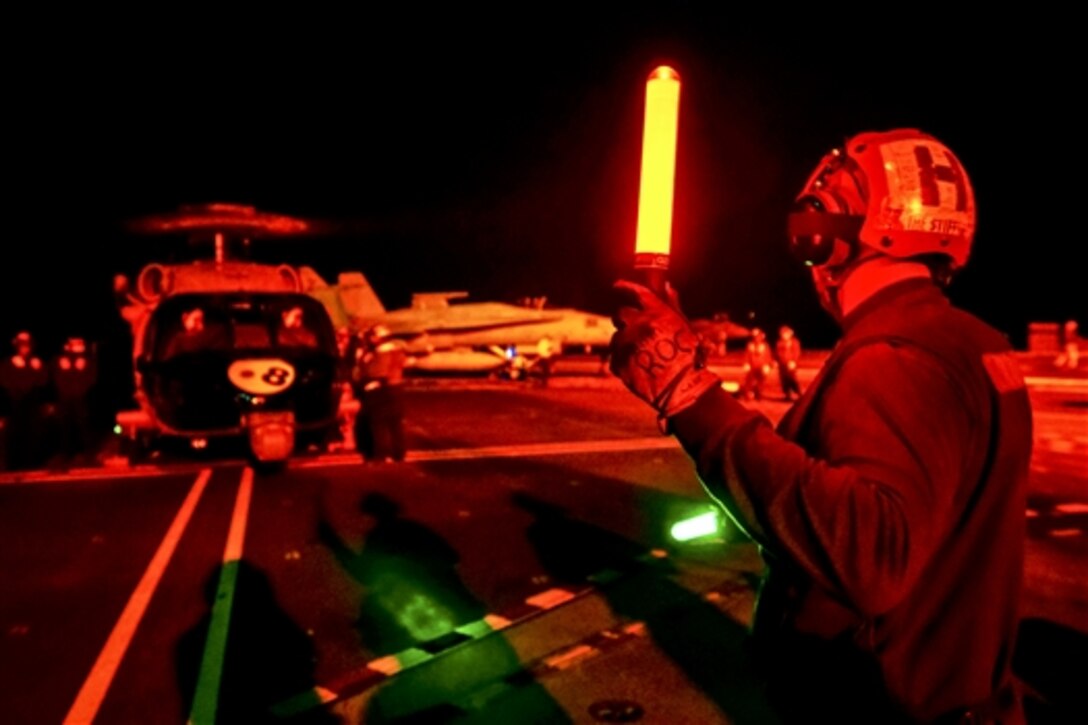 U.S. Navy Airman Ryan Carpenter prepares an MH-60S Seahawk helicopter for takeoff on the flight deck of the aircraft carrier USS John C. Stennis in the Pacific Ocean, Jan. 24, 2015. The Stennis is conducting an operational training mission.