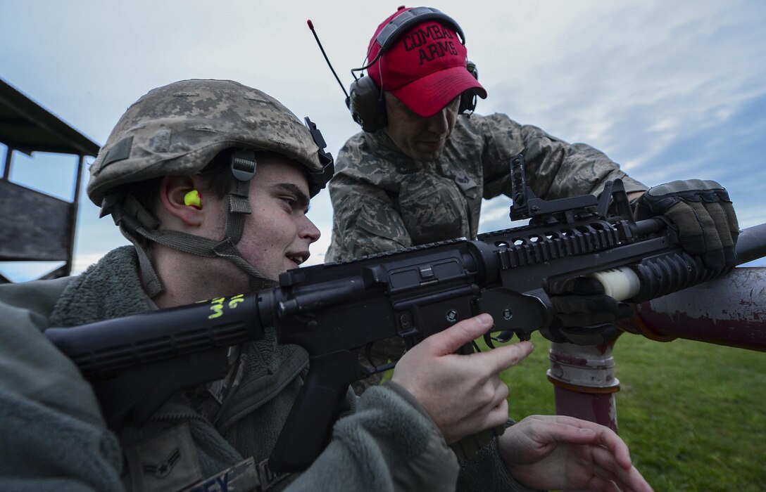 Staff Sgt. Alan Daly gives range correction instructions to Airman 1st Class Brennan Eisenbrey during an M203 grenade launcher qualification course Dec. 12, 2014, at Royal Air Force Feltwell, England. Combat arms training and maintenance instructors ensure the safe and effective operation of weapon systems. Daly is a 48th Security Forces Squadron combat arms instructor and Eisenbrey is a 48th SFS response force member. (U.S. Air Force photo/Airman 1st Class Erin R. Babis)