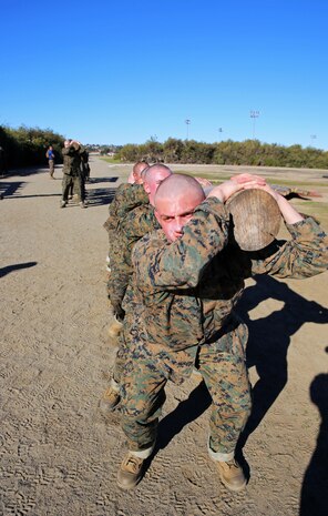 Recruits if India Company, 3rd Recruit Training Battalion, conduct squats during a log drill exercise at Marine Corps Recruit Depot San Diego, Calif., Jan. 6. Log drill exercises are conducted in groups of eight and require teamwork to accomplish