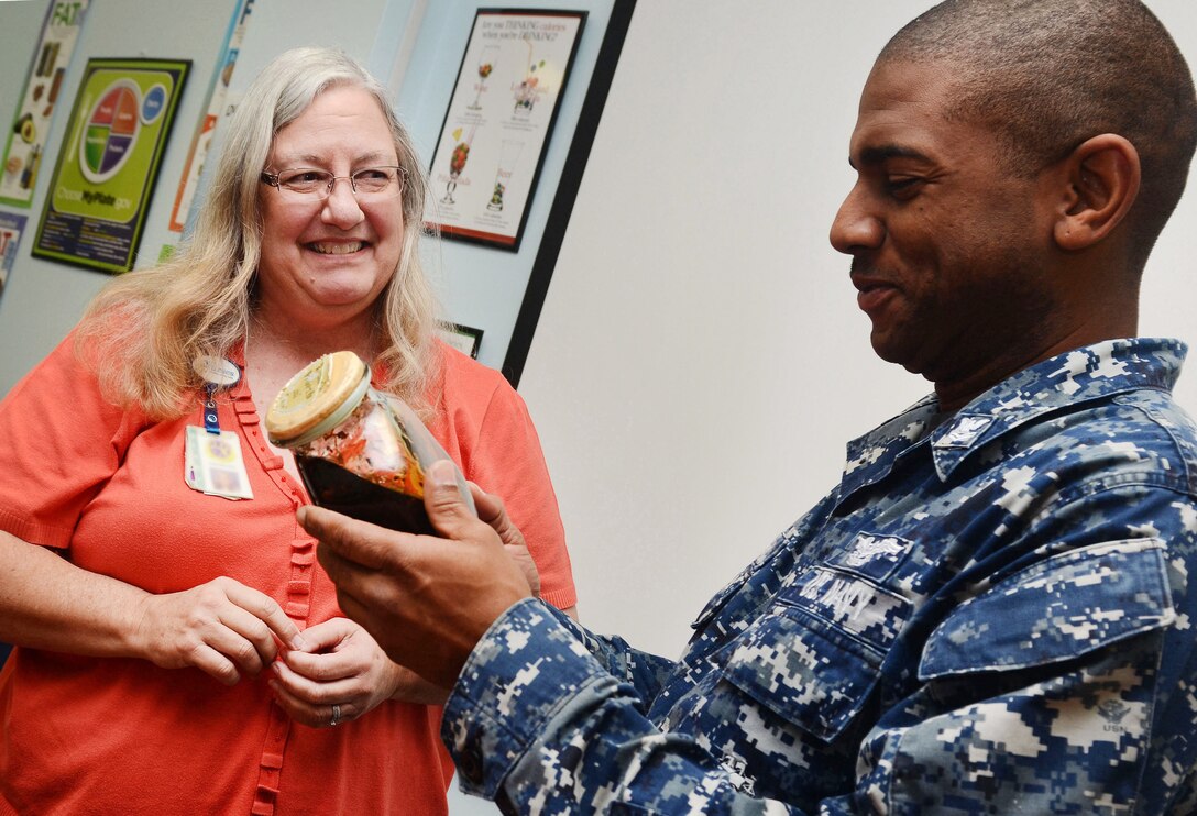 Charlene Rees (left), Naval Hospital Jacksonville, Fla., smoking cessation coordinator, explains the effects of smoking tobacco by showing examples of tar build-up in the lungs to a sailor at the Wellness Center aboard Naval Air Station Jacksonville, Fla. NBHC Albany's Health Promotions offer Tobacco Cessation and other health and wellness programs for active duty, retirees and family members. 
