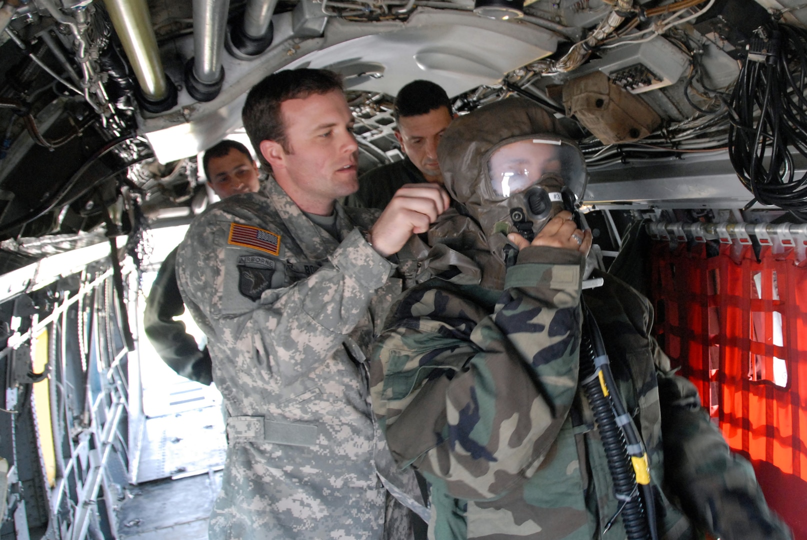 Chief Warrant Officer-2 Lucas Bohm (left) along with Chief Warrant Officer-2 Lance Stafford, helicopter pilots assigned to the Illinois Army National Guard, help outfit one of their Tunisian Army counterparts with a U.S. Air Force issue chemical suit during the Medlite-10 Exerise. Chiefs Stafford and Bohm, along with Air National Guard and Army Reservists from Wyoming, Arizona, and Nevada traveled to northern Africa to help enhance the medical capabilities and interoperabilities between United States and Tunisian forces.