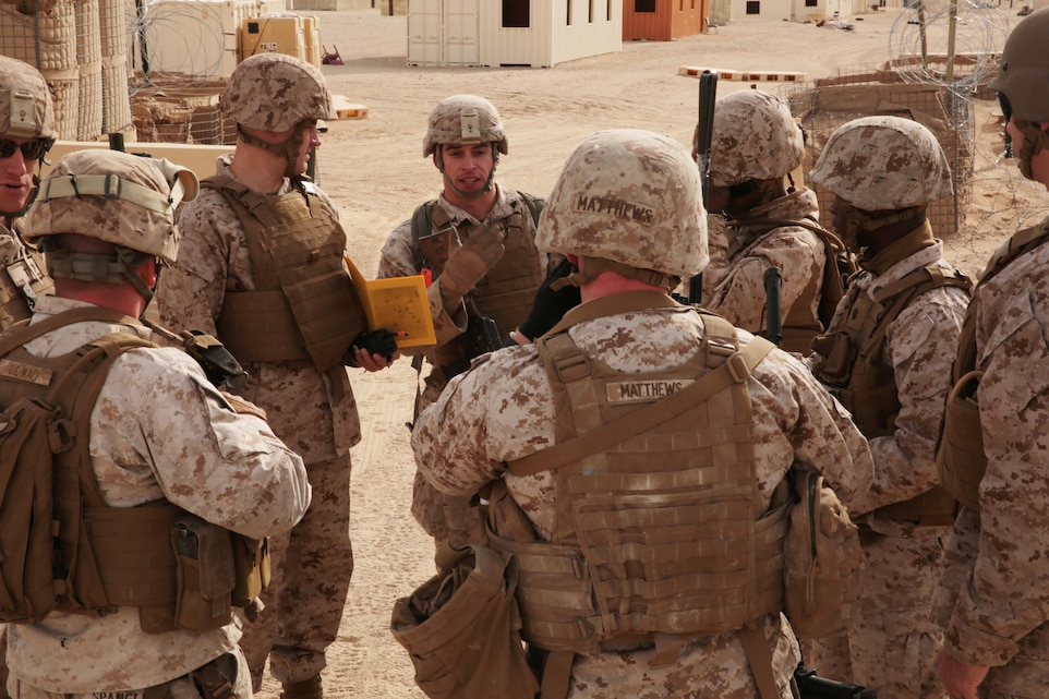Marines and Religious Ministry Teams gather for a brief on their next objective during the Combat Center’s Chaplain and Religious Program Specialist Expeditionary Training on range 215, Jan. 20, 2015. The training was held to condition RMTs for combat situations and is the first of its kind. (Official Marine Corps photo by Lance Cpl. Medina Ayala-Lo/Released)