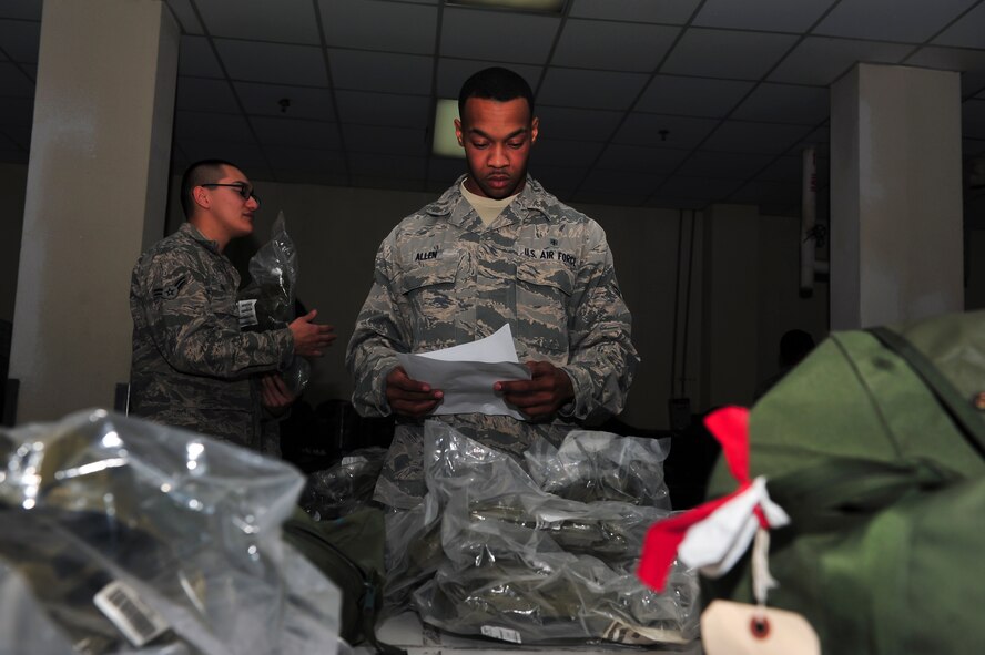 Airman 1st Class Daveon Allen, 51st Medical Support Squadron resource management office journeyman, looks over his checklist to ensure he has all of the necessary gear in his real world bag at the 51st Logistic Readiness Squadron individual protective equipment building Jan. 27, 2015, at Osan Air Base, Republic of Korea. The mission of the IPE unit is to ensure that all essential personnel in-processing at Osan receives their chemical gear. (U.S. Air Force photo by Senior Airman David Owsianka)