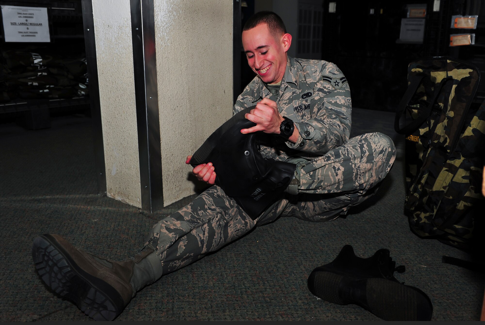 Airman 1st Class Nicholas Goncalves, 36th Aircraft Maintenance Unit crew chief, removes his training boots after ensuring they fit at the 51st Logistic Readiness Squadron individual protective equipment building Jan. 27, 2015, at Osan Air Base, Republic of Korea. All mission essential personnel will receive their gear within the first 10-days upon arriving on station. (U.S. Air Force photo by Senior Airman David Owsianka)