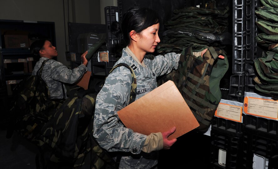 Airmen pick up their vest and plates at the 51st Logistic Readiness Squadron individual protective equipment building Jan. 27, 2015, at Osan Air Base, Republic of Korea. In nuclear, biological and chemical warfare, IPE clothing and equipment are used to protect an individual from biological and chemical hazards and some nuclear effects. (U.S. Air Force photo by Senior Airman David Owsianka)