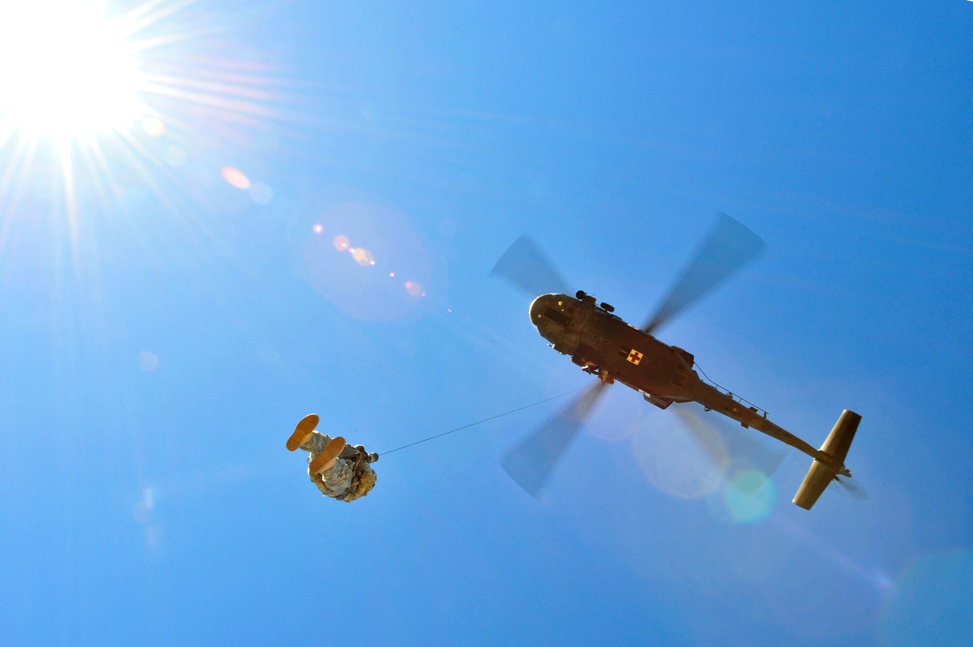 Arizona Army National Guard Sgt. Kevin Murphy, Detachment 1, C Company, 5-159th Air Ambulance flight medic, rides a hoist up a UH-60A Black Hawk helicopter during a joint training exercise held in southern Arizona, Jan. 20, 2015.  The joint training consisted of A-10C Thunderbolt IIs from the 354th Fighter Squadron, based out of Davis-Monthan Air Force Base, and the UH-60A Black Hawk helicopter from Detachment 1, C Company, 5-159th Air Ambulance, based out of Phoenix, conducting close air support and combat search and rescue exercises.  (U.S. Air Force Photo by Airman 1st Class Chris Massey/Released)