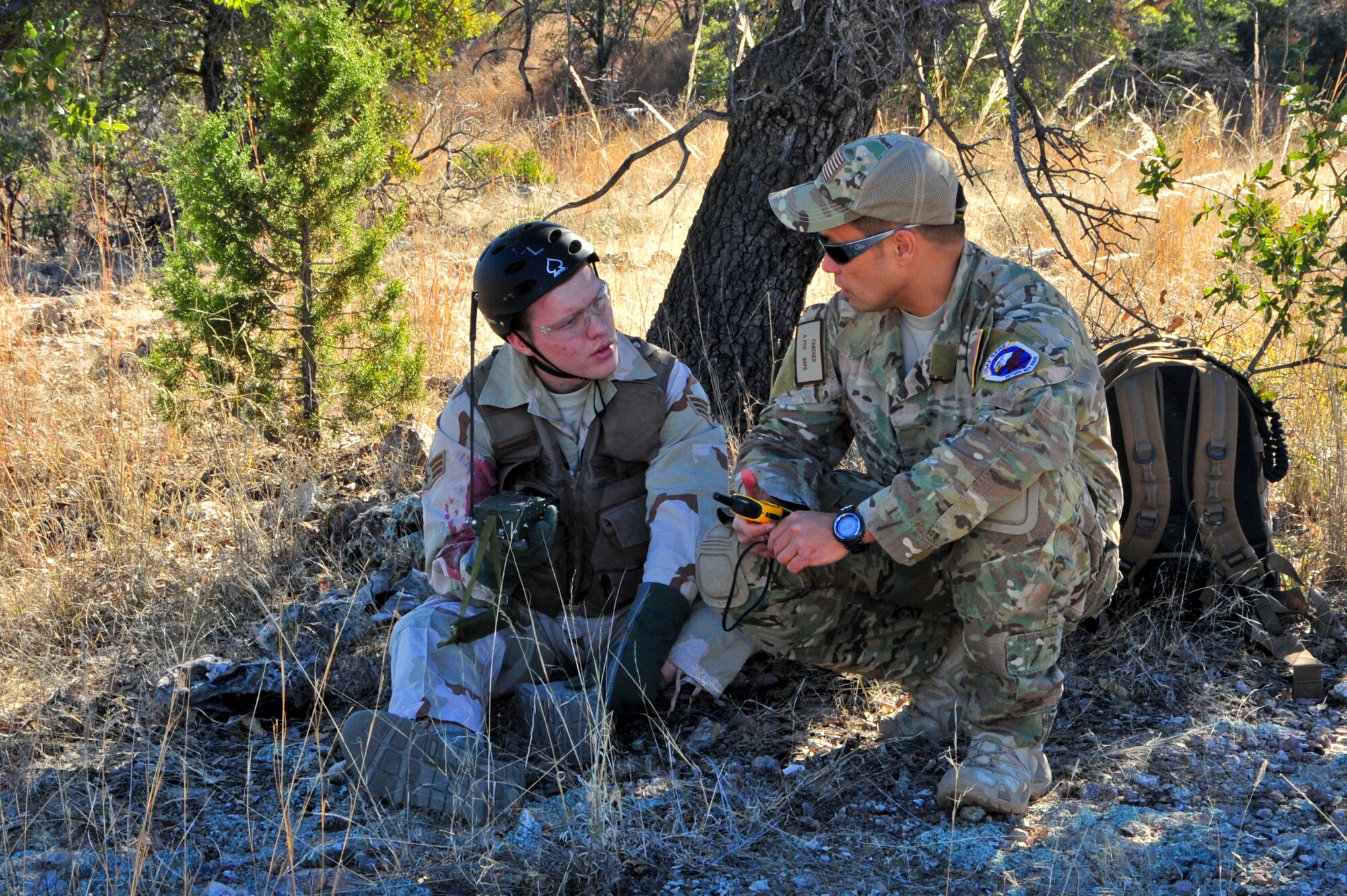(Right to Left) U.S. Air Force Tech. Sgt. Tony Fancher, 355th Operations Support Squadron survival, evasion, resistance and escape specialist, instructs Airman 1st Class Hunter Young, 355th Operations Support Squadron aircrew flight equipment technician, how to communicate his location to an aircraft during a joint training exercise at a southern Arizona military training range, Jan. 20, 2015. Young was simulating a downed pilot during the close air support and combat search and rescue training.  (U.S. Air Force Photo by Airman 1st Class Chris Massey/Released)