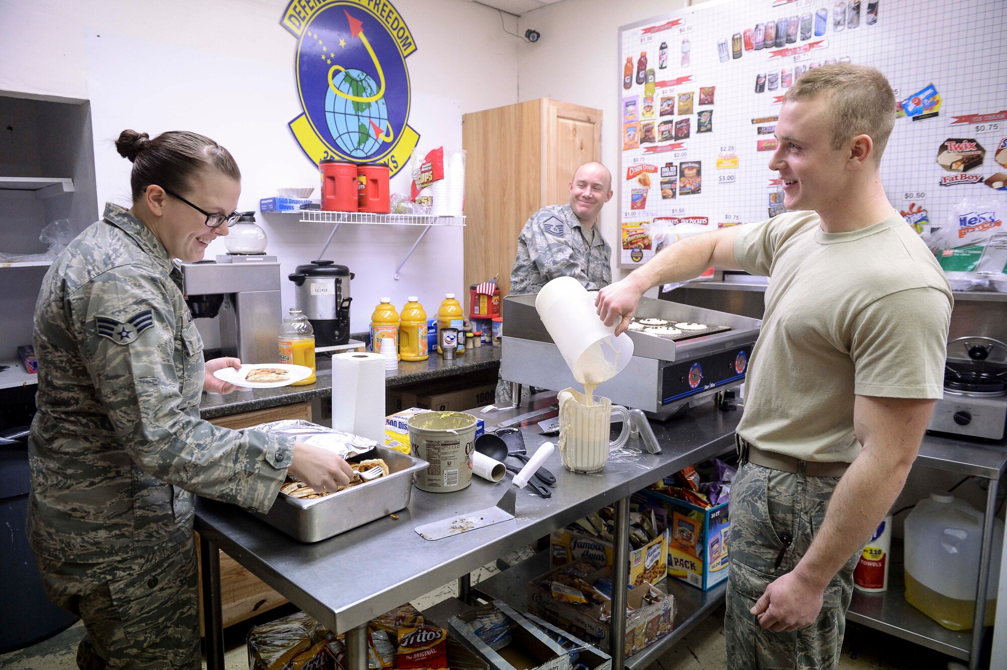 U.S. Air Force Senior Airman Savannah Lampe, an aerospace ground equipment journeyman, Master Sgt. Bryan Hinton, the accessories flight chief, and 2nd Lt. Eric Millen, the maintenance flight commander, all assigned to the 354th Maintenance Squadron, enjoy a pancake breakfast at the 18th Aircraft Maintenance Unit (AMU) hangars, Eielson Air Force Base, Alaska, Jan. 15, 2014. Leadership at 18th AMU helped with their Airmen's morale by cooking breakfast for maintainers while they worked to launch numerous aircraft simultaneously for a large-scale exercise. (U.S. Air Force Photo by Senior Airman Peter Reft/Released)
