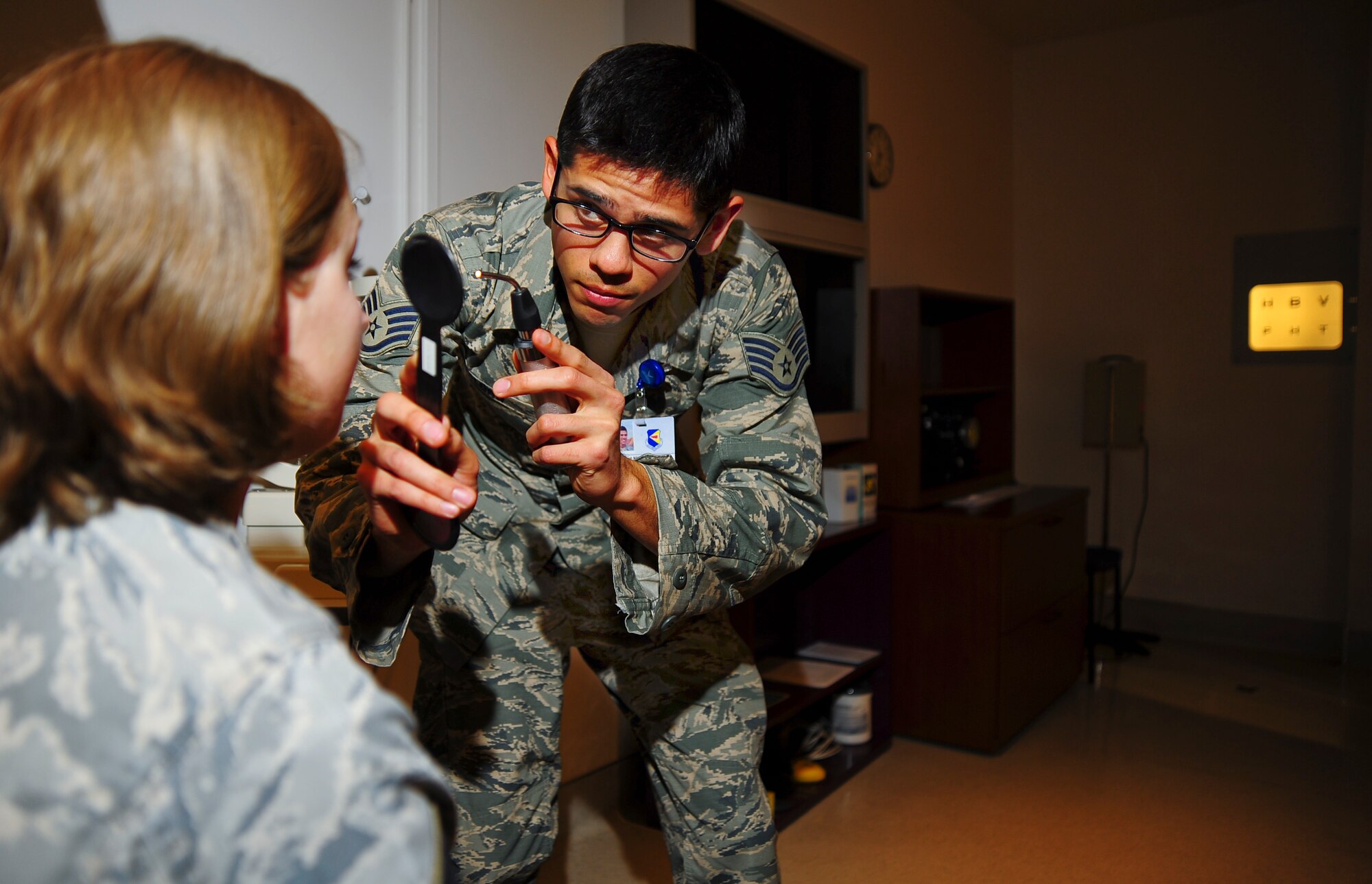 U.S. Air Force Staff. Sgt. Nick DeLong, 355th Aerospace Medicine Squadron optometry NCO in charge, performs a cover test on a patient at Davis-Monthan Air Force Base, Ariz., Jan. 28, 2015.  There are 2,400 officers, and 5,800 enlisted members in parallel career fields that encompass the Biomedical Sciences Corps. (U.S. Air Force photo by Staff Sgt. Angela Ruiz)