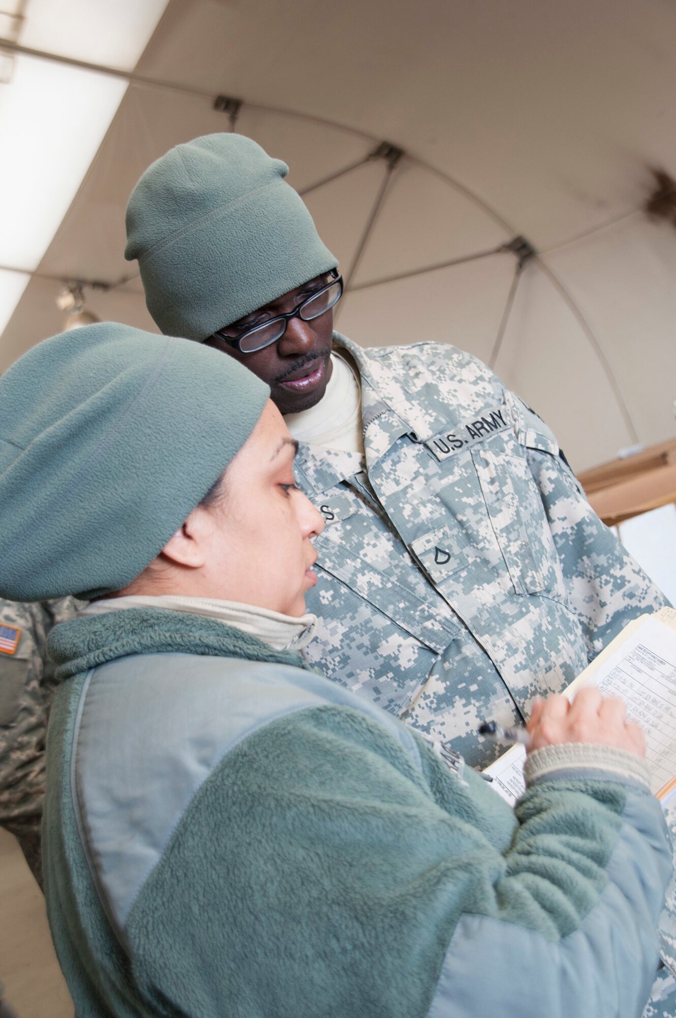 Pfc. Jermey Selders, 321st Sustainment Brigade supply specialist, from Baton Rouge, La., assists Staff Sgt. Rosemary Lopez with the supply documentation process at WAREX on Joint Base McGuire-Dix-Lakehurst, N.J. (Photo by Sgt. Ferdinand Thomas/Released)