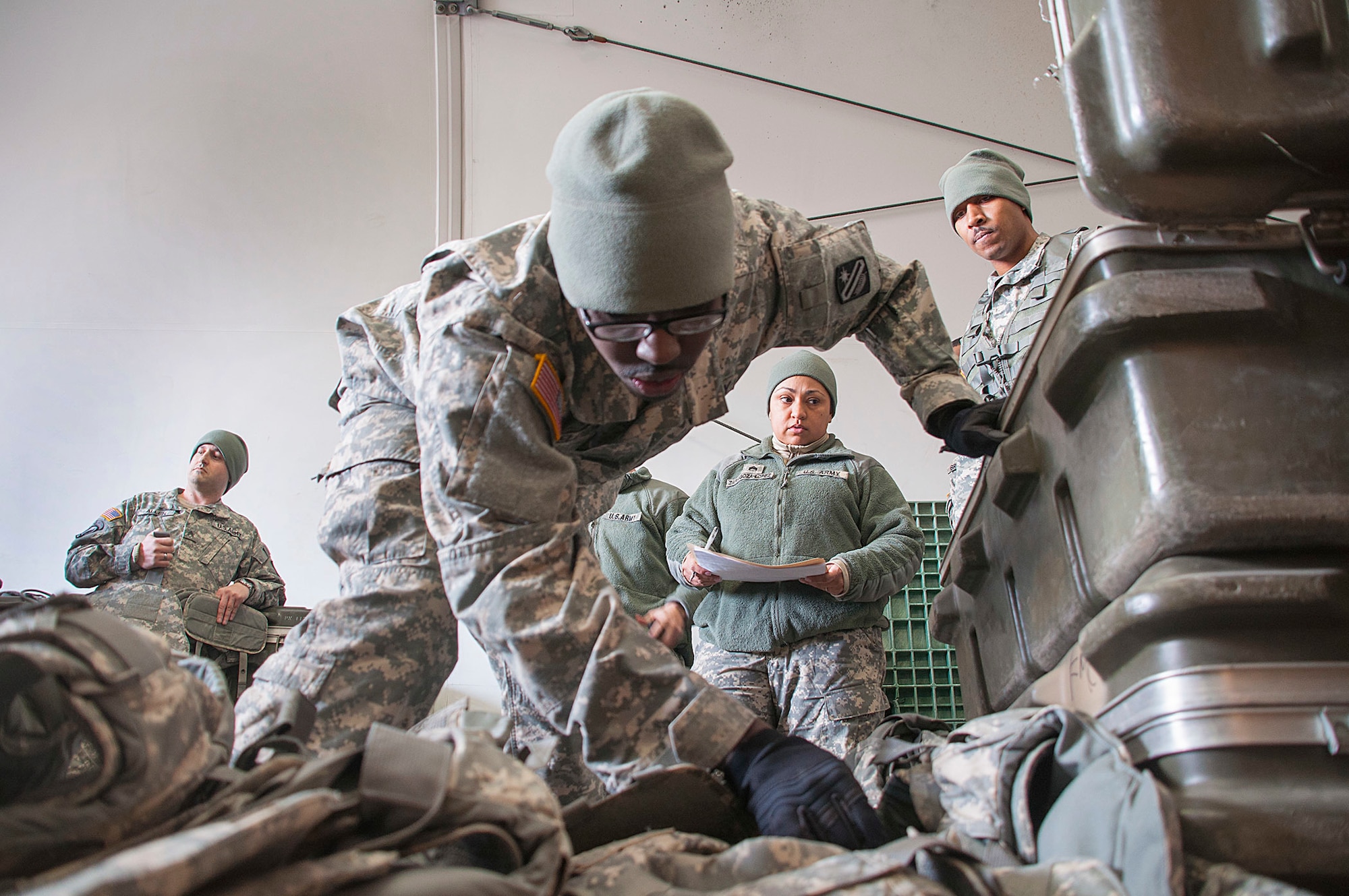 Pfc. Jermey Selders, 321st Sustainment Brigade supply specialist, from Baton Rouge, La., inspects improved outer tactical vests before issuing them to various Soldiers participating in WAREX at Joint Base McGuire-Dix-Lakehurst, N.J. Staff Sgt. Rosemary Lopez and Army Sgt. Paul Robbins look on as their supply Soldier learns how to lead from the front. (Photo by Sgt. Ferdinand Thomas/Released)
