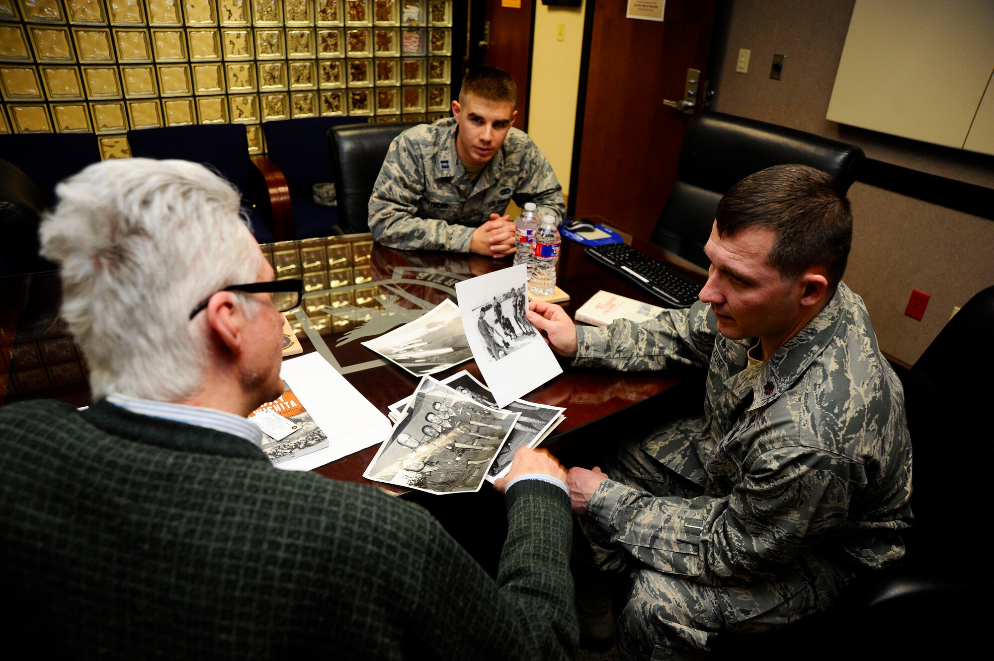 (From right) Maj. Robert Clouse, 22nd Security Forces Squadron commander, and Capt. Thomas Matechik, 22nd SFS operations officer, discuss photos from the Vietnam War with Stephen Carlton, Jan. 15, 2014, at McConnell Air Force Base, Kan. Carlton, a former McConnell air police lieutenant in the 1960s, received the opportunity to meet with current security forces Airmen and share his experiences from his time in the Air Force. (U.S. Air Force photo/Senior Airman Victor J. Caputo)