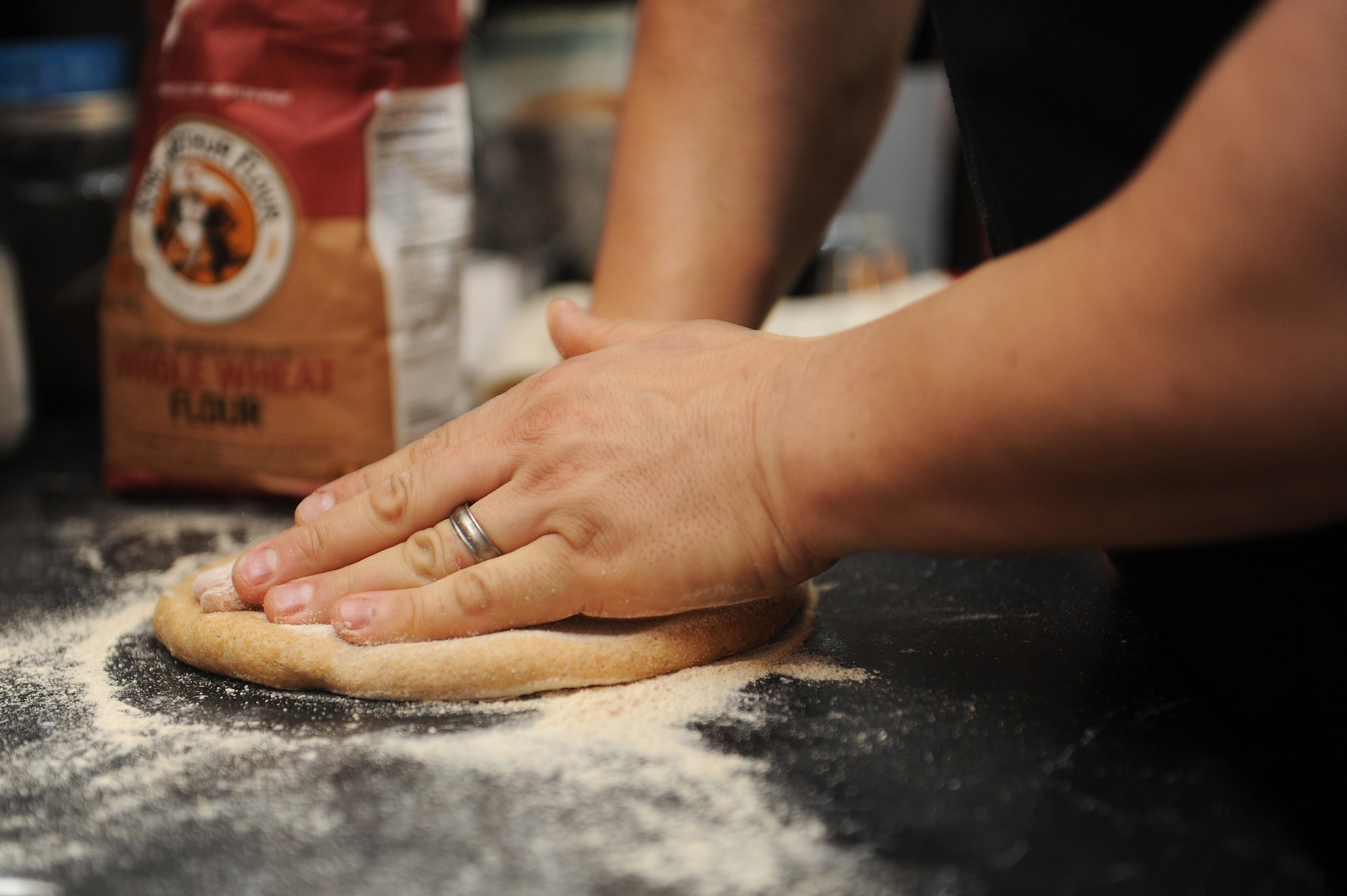 Master Sgt. Scott Stuehrenberg kneads whole-wheat pizza dough, smoothing out imperfections.  Stuehrenberg cooks meals for him and his family, in order to know what’s going into his body.  Counting calories and monitoring nutritional value helped him and his wife lose weight and become healthy.  Stuehrenberg is a 618th Air and Space Operations global operations manager.  (U.S. Air Force photo by Staff Sgt. Maria Bowman)