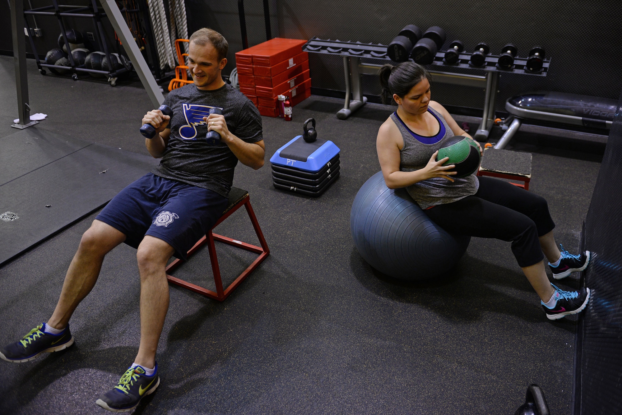 Jessi McNulty, 26, and her husband Staff Sgt. Stephen McNulty, a 375th Civil Engineering Squadron Firefighter, performs an abdominal exercise, ‘russian twists’, at their gym, O’Fallon, Ill., Jan. 22, 2015. This Air Force spouse has been hitting this gym for nearly two years, during which time she has lost 90 pounds despite having temporal lobe epilepsy. Generally her workouts are total body-oriented. She and Myers monitor her heart rate to mitigate her seizures, which are exercise-induced. (U.S. Air Force photo by Airman 1st Class Erica Crossen)