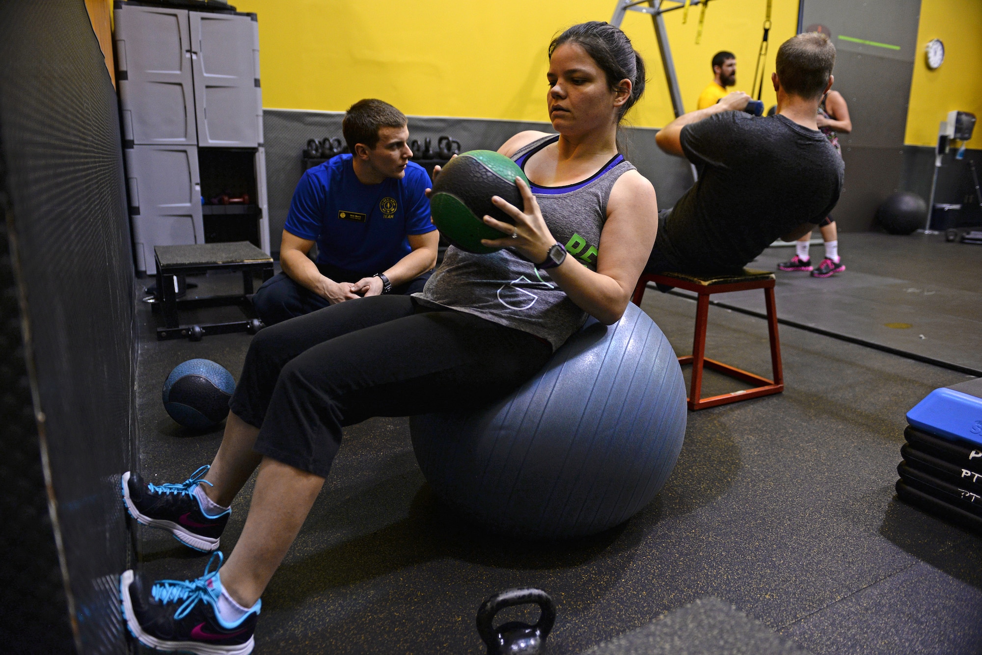 Jessi McNulty, 26, performs an abdominal exercise, ‘russian twists’, while her personal trainer Nate Myers supervises her for correct form, O’Fallon, Ill., Jan. 22, 2015. This Air Force spouse has been hitting this gym for nearly two years, during which time she has lost 90 pounds despite having temporal lobe epilepsy. Generally her workouts are total body-oriented. She and Myers monitor her heart rate to mitigate her seizures, which are exercise-induced. (U.S. Air Force photo by Airman 1st Class Erica Crossen)