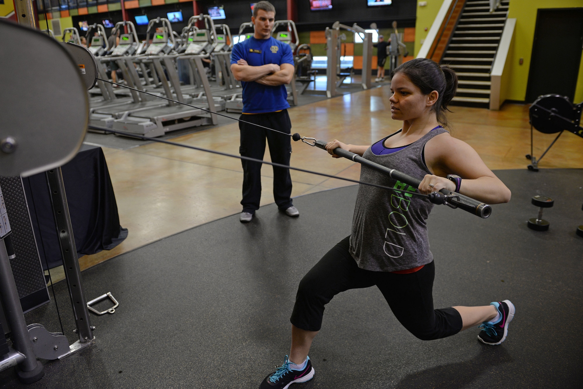 Jessi McNulty, 26, uses an upper body machine while her personal trainer Nate Myers watches her for correct form, O’Fallon, Ill., Jan. 22, 2015. This Air Force spouse has been hitting this gym for nearly two years, during which time she has lost 90 pounds despite having temporal lobe epilepsy. Generally her workouts are total body-oriented. She and Myers monitor her heart rate to mitigate her seizures, which are exercise-induced. (U.S. Air Force photo by Airman 1st Class Erica Crossen)