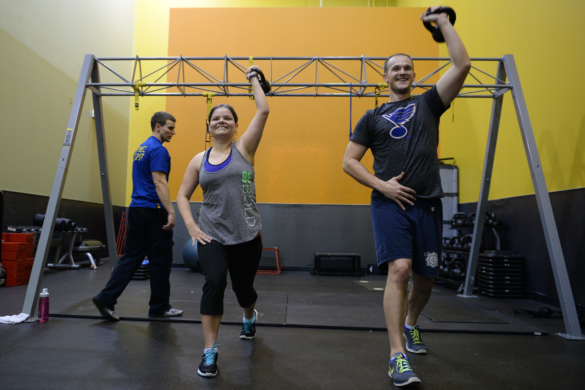 Jessi McNulty, 26, and her husband Staff Sgt. Stephen McNulty, a 375th Civil Engineering Squadron Firefighter, performs kettle bell lunges at their gym, O’Fallon, Ill., Jan. 22, 2015. Jessi has been hitting this gym for nearly two years, during which time she has lost 90 pounds despite having temporal lobe epilepsy. Generally her workouts are total-body-oriented and her and her personal trainer monitors her heart rate to mitigate her seizures, which are exercise-induced. (U.S. Air Force photo by Airman 1st Class Erica Crossen)