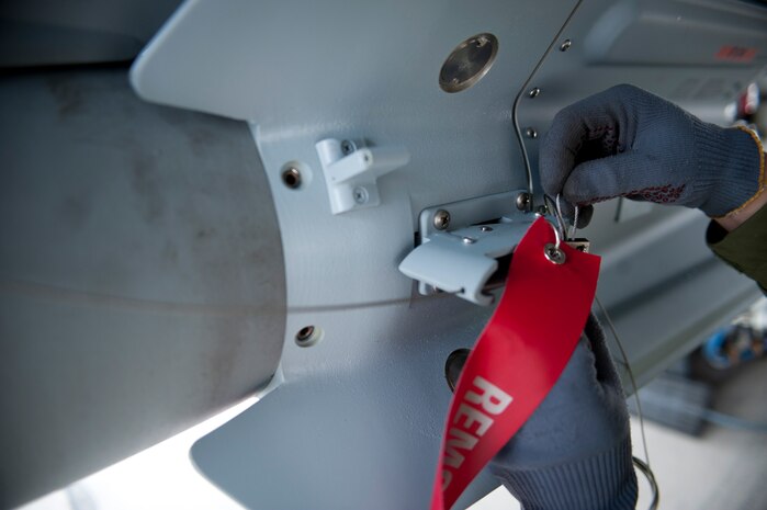 A Royal Air Force weapons technician assigned to 6 Squadron, RAF Lossiemouth, Scotland, performs final inspections on a live bomb prior to a Red Flag 15-1 training sortie at Nellis Air Force Base, Nev., Jan. 27, 2015. Southern Nevada’s 2.9 million acre Nevada Test and Training Range has been the arena for Red Flag exercises since 1975, and offers the ability for aircrews to drop live ordinance safely in training scenarios. (U.S. Air Force photo by Airman 1st Class Joshua Kleinholz)