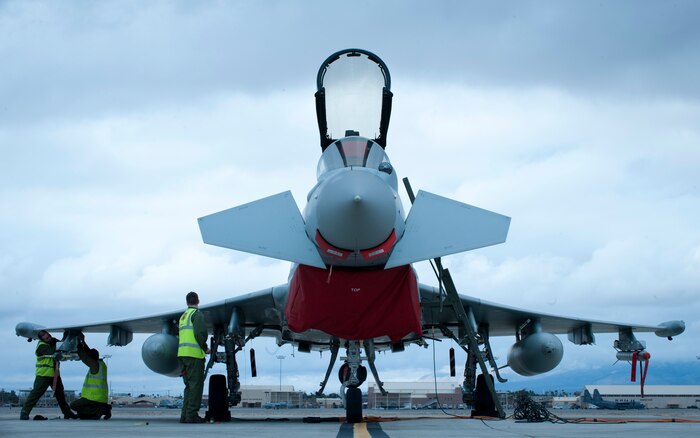 Royal Air Force weapons technicians assignment to 1 (Fighter) Squadron, RAF Lossiemouth, Scotland, prepare a Typhoon FGR4 fighter to receive a live bomb load prior to a Red Flag 15-1 training sortie at Nellis Air Force Base, Nev., Jan. 27, 2015. Aircraft tasked with carrying live weapons are towed to a live ordinance loading area to ensure their safest application possible. (U.S. Air Force photo by Airman 1st Class Joshua Kleinholz)