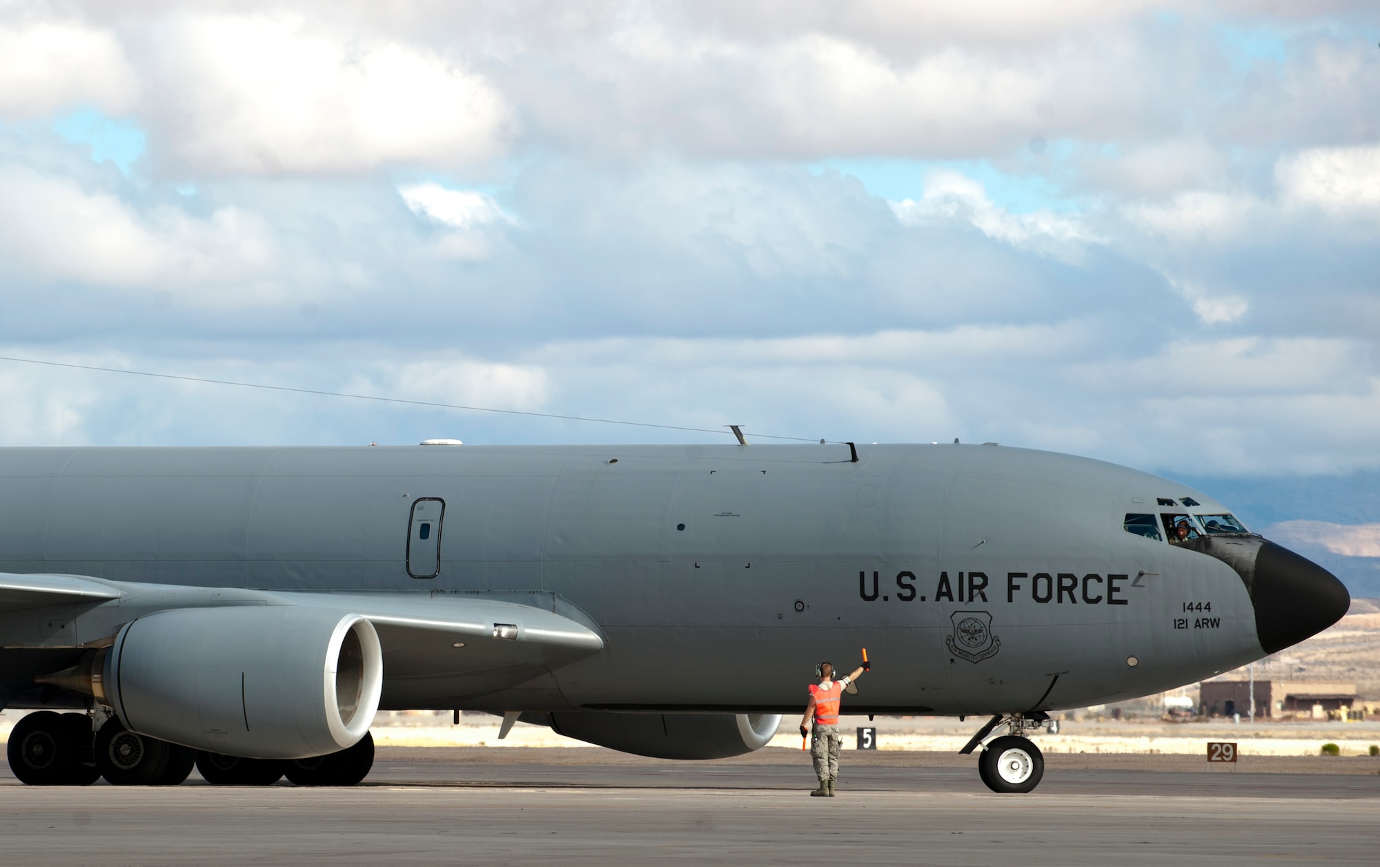 An Ohio Air National Guard crew chief marshalls a KC-135 Stratotanker assigned to the 121st Aerial Refueling Wing, Rickenbacker Air National Guard Base, Ohio, on the flightline during Red Flag 15-1 at Nellis Air Force Base, Nev., Jan 27, 2015. In addition to providing fuel for aircraft in mid-air, the KC-135 can carry up to 83,000 pounds of cargo. (U.S. Air Force photo by Senior Airman Thomas Spangler)