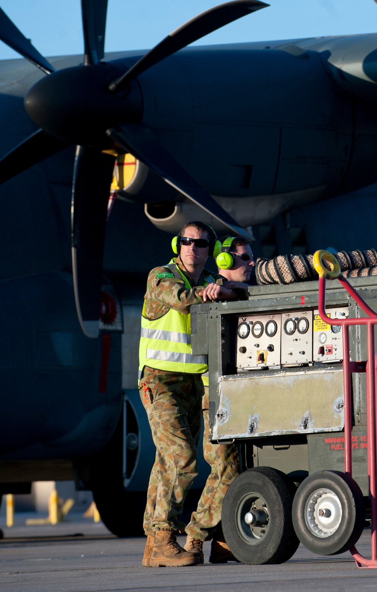 Two Royal Australian air force aircraft maintainers wait for their aircraft to return from a training mission during Red Flag 15-1 at Nellis Air Force Base, Nev., Jan. 27, 2015. Red Flag exercises provide allied air forces the opportunity to train in a joint combat environment. (U.S. Air Force photo by Senior Airman Thomas Spangler)