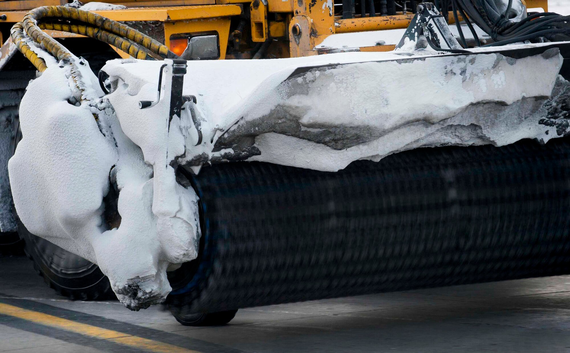 A snow broom removes snow from the flightline on Minot Air Force Base, N.D., Jan. 21, 2015. The brooms are used for sweeping up light snow and ice that is left on the pavement after a snow plow has cleared an area. (U.S. Air Force photo/Airman 1st Class Sahara L. Fales) 