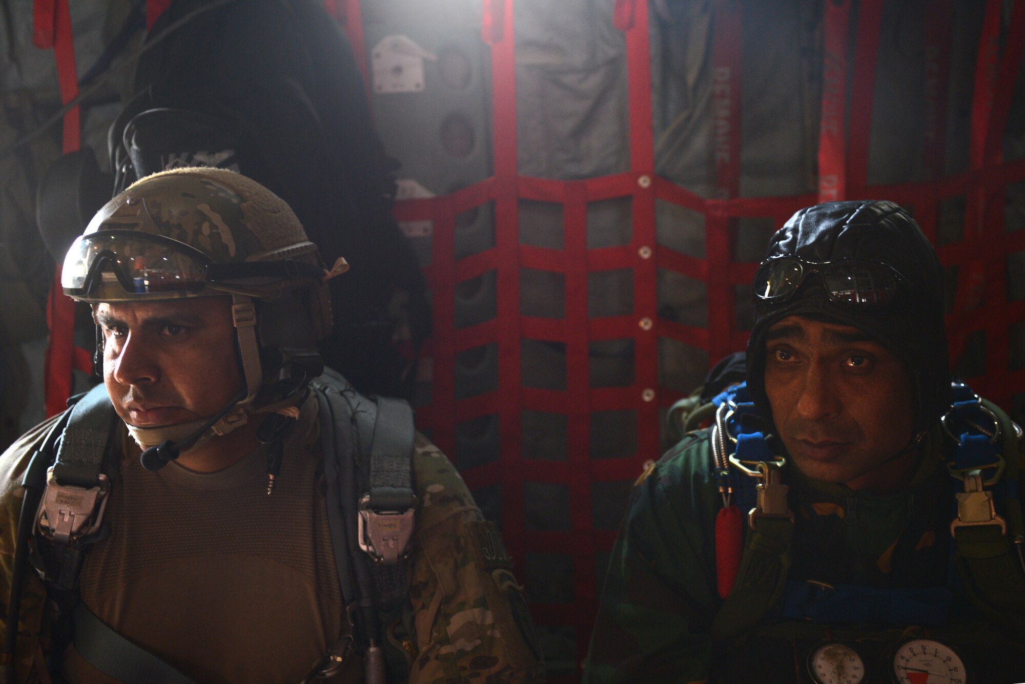 U.S. Air Force Master Sgt. Bobby Pena, right, a Tactical Air Control Party member assigned to the 3rd Air Support Operations Squadron, Joint Base Elmendorf Richardson, Alaska, sits next to a Bangladeshi jumpmaster during a personnel airdrop mission at Exercise COPE SOUTH near Sylhet, Bangladesh, Jan. 25, 2015. COPE SOUTH is a Pacific Air Forces-sponsored, bilateral tactical airlift exercise conducted in Bangladesh, with a focus on cooperative flight operations, day and night low-level navigation, tactical airdrop, and air-land missions as well as subject-matter expert exchanges in the fields of operations, maintenance and rigging disciplines. (U.S. Air Force photo by 1st Lt. Jake Bailey/Released)