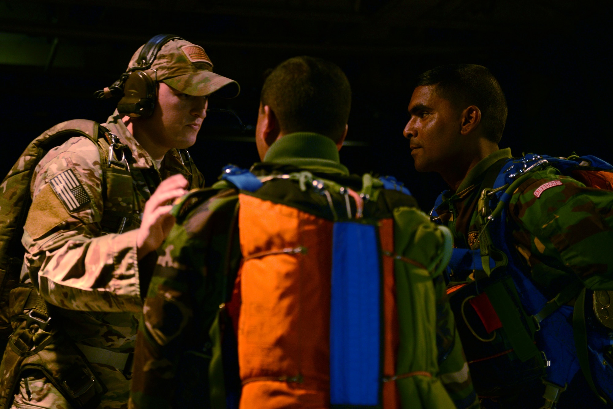 Staff Sgt. Ben Johnis, left, a S.E.R.E. instructor assigned to the 374th Operations Support Squadron, Yokota Air Base, Japan, coordinates with Bangladeshi Army jumpmasters before a personnel drop mission during Exercise COPE SOUTH Jan. 25, 2015. COPE SOUTH is a Pacific Air Forces-sponsored, bilateral tactical airlift exercise conducted in Bangladesh, with a focus on cooperative flight operations, day and night low-level navigation, tactical airdrop, and air-land missions as well as subject-matter expert exchanges in the fields of operations, maintenance and rigging disciplines. (U.S. Air Force photo by 1st Lt. Jake Bailey/Released)