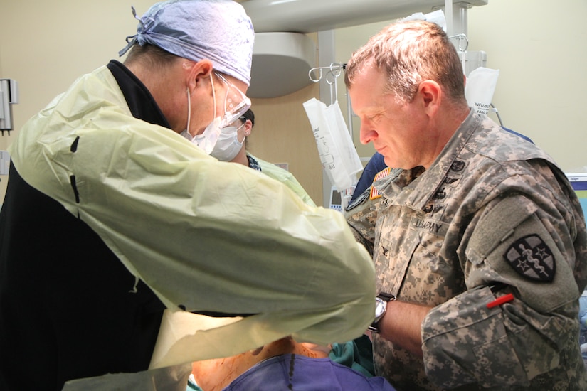 A surgeon from Fort Belvior Community Hospital performs a surgical procedure on a simulated patient as a soldier from 1st Medical Training Brigade oversees the event on Fort Belvoir, Va., Jan. 21, 2015. (U.S. Army photo by Spc. Philip Scaringi/Released)