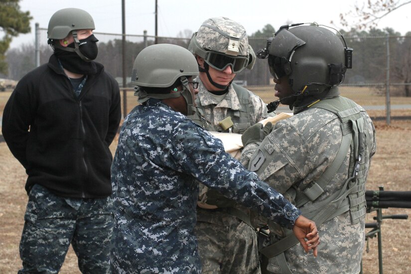 Army and Navy Reserve ground ambulance personnel from the 75th Combat Support Hospital transport a simulated patient to a crew chief from 2nd Battalion, 1st Combat Aviation Brigade, 1st Infantry Division on Fort A.P. Hill, Va., Jan. 21, 2015. (U.S. Army photo by Spc. Mathew Elmore/Released)