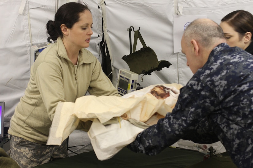 Capt. Kimberly Middleton, 75th Combat Support Hospital, transfers a simulated patient to Cmdr. Patrick Gregory, Expeditionary Medical Facility Bethesda, on Fort A.P. Hill, Va., Jan. 21, 2015. (U.S. Army photo by Spc. Mathew Elmore/Released)
