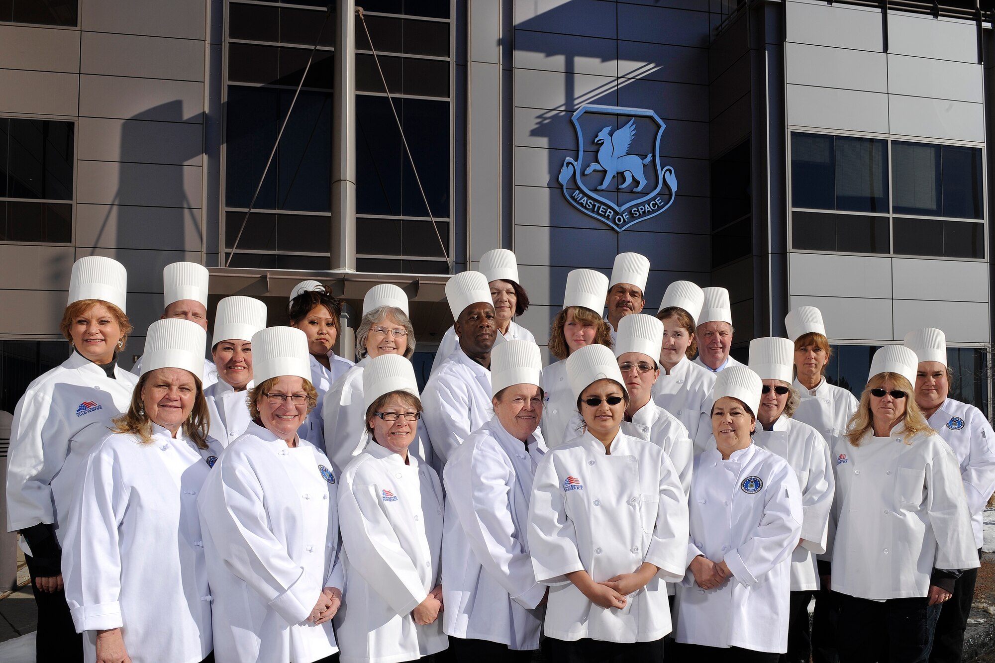 The Satellite Dish dining facility staff poses for a photo in front of the 50th Space Wing Headquarters Building 200 after winning the 2014 Air Force Space Command Hennessy award Jan. 2, 2015, at Schriever Air Force Base, Colo. The Dish will be competing at the Air Force level next month. (U.S. Air Force photo/Dennis Rogers) 