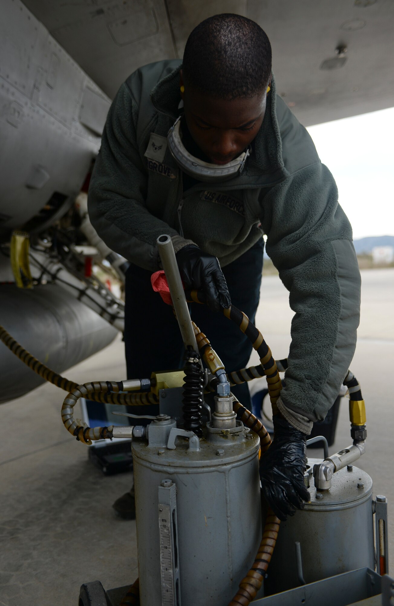U.S. Air Force Airman 1st Class Kendrick Hargrove, a dedicated crew chief assigned to the 52nd Expeditionary Aircraft Maintenance Squadron, prepares to use an oil car to service the hydraulics inside an F-16 Fighting Falcon fighter aircraft during a flying training deployment on the flightline at Souda Bay, Greece, Jan. 27, 2015. Hargrove used the oil to replenish the aircraft's hydraulics which are used for control when in flight. Hargrove participated alongside other maintainers as part of the deployment between the U.S. and Greek air forces at Souda Bay. (U.S. Air Force photo by Staff Sgt. Joe W. McFadden/Released)