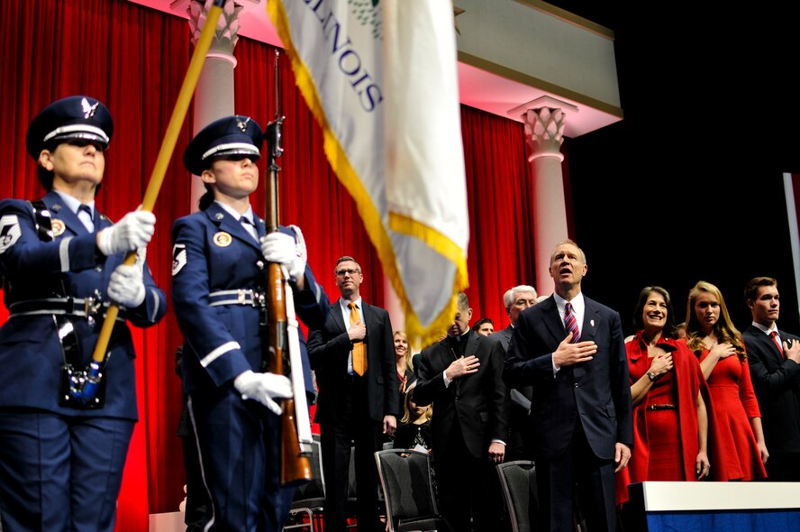 Governor-elect Bruce V. Rauner, 4th from right, sings along to "The Star-Spangled Banner" as an Illinois National Guard color guard team posts the colors at Rauner's inauguration ceremony in Springfield, Ill., Jan. 12, 2015. As Illinois' governor, Rauner will serve as the commander in chief for the Soldiers and Airmen of the Illinois National Guard while they are not under federal activation. (U.S. Air National Guard photo by Staff Sgt. Lealan Buehrer/Released)