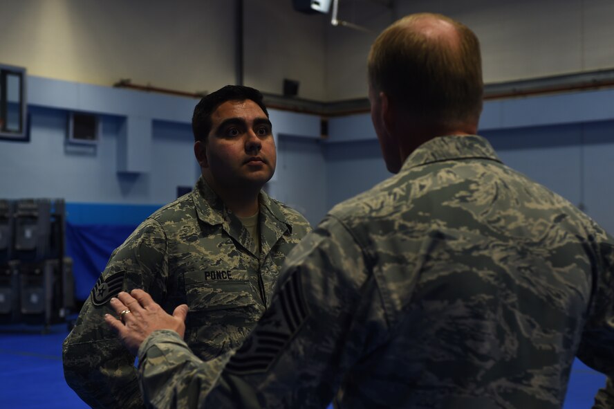 Staff Sgt. Cesar Ponce, from the 422nd Communications Squadron, left, speaks with Chief Master Sgt. of the Air Force James A. Cody following an all-call at RAF Croughton, England, Jan. 28, 2015. During his two-day visit to the United Kingdom, Cody toured RAF Alconbury and Croughton, and saw firsthand how Airmen of the 501st Combat Support Wing are making innovation a part of their daily lives. (U.S. Air Force photo by Staff Sgt. Jarad A. Denton/Released) 