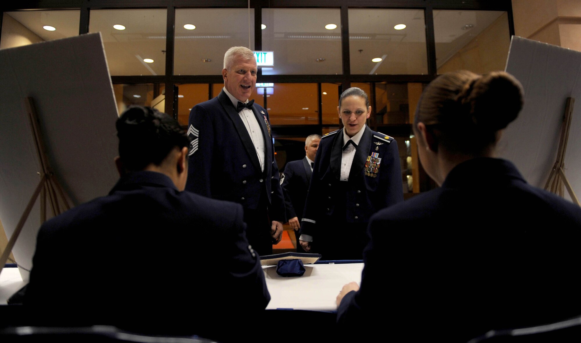 Attendees sign in at the front desk before the Chief Master Sergeant Recognition Ceremony in Club Eifel at Spangdahlem Air Base, Germany, Jan. 23, 2015. The 52nd Fighter Wing recognized seven senior master sergeants for earning the rank of chief master sergeant. (U.S. Air Force photo by Airman 1st Class Timothy Kim/Released)