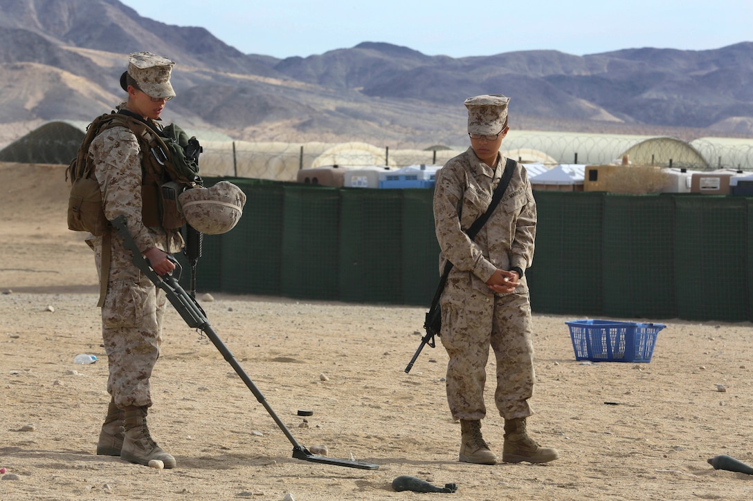 Marine Corps Lance Cpl. Hollie Campbell, right, teaches a Marine how to ...