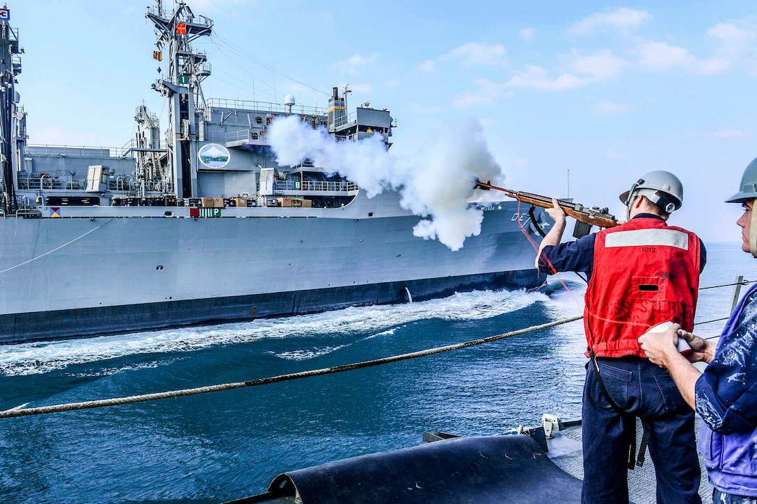 U.S. Navy Petty Officer 2nd Class Dylan Dennison fires a shot line from the guided-missile destroyer USS Sterett to the Maritime Sealift Command fleet replenishment oiler USNS Rainier during a replenishment-at-sea in the U.S. 5th Fleet area of operations, Jan. 23, 2015. Dennison is a gunner's mate. The Sterett is deployed as part of the Carl Vinson Carrier Strike Group in support of Operation Inherent Resolve, strike operations in Iraq and Syria as directed, maritime security operations, and theater security cooperation efforts in the region. 